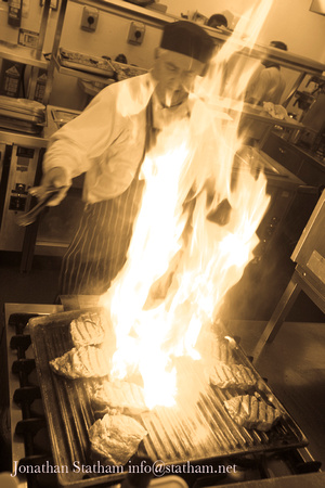 Chef flaming steaks for forthcoming banquet Chancellors Hotel